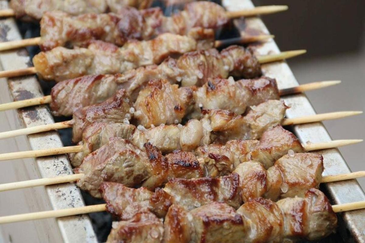 a bunch of food on a grill with chop sticks