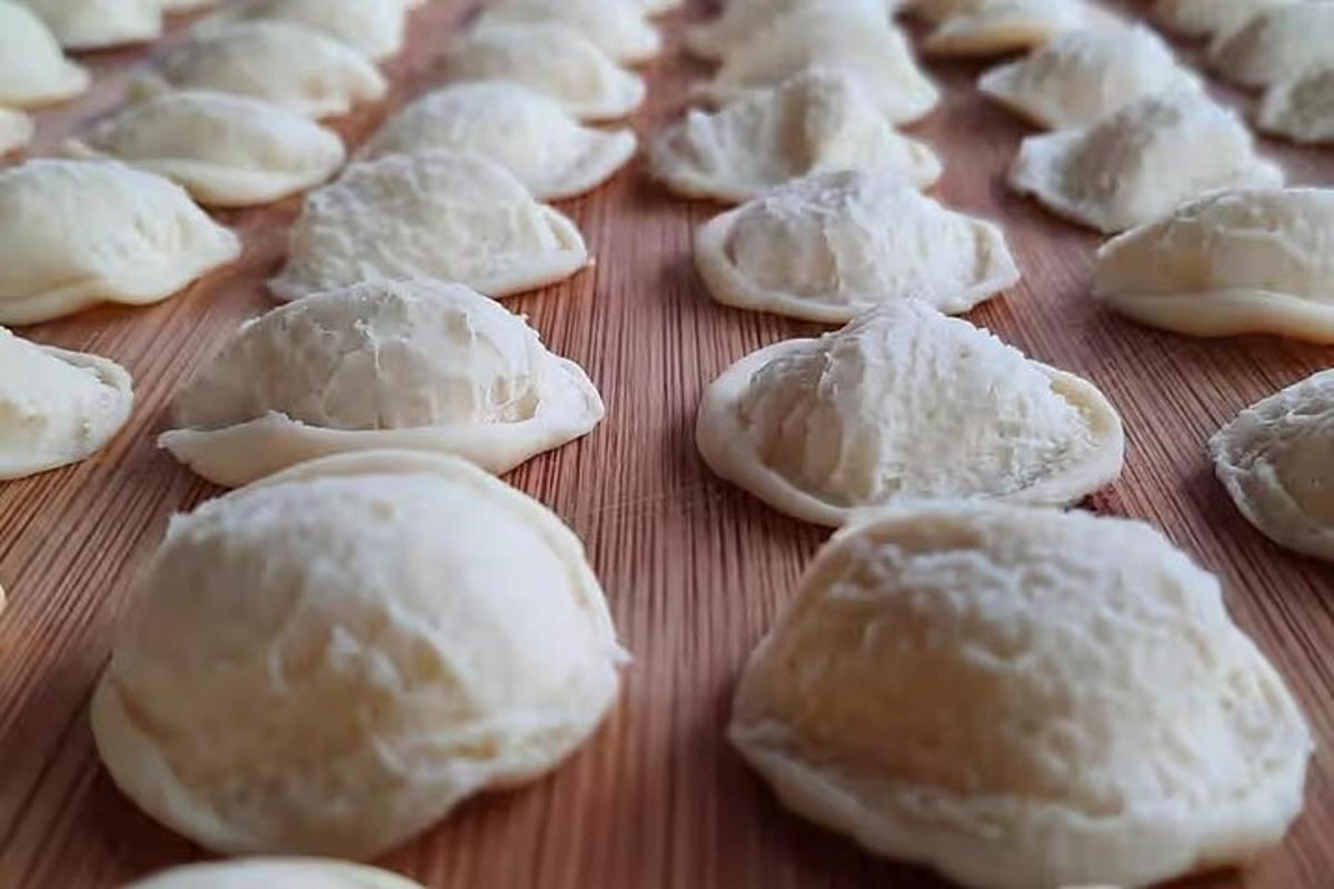 hópur af óelduðum dumplings á tréborði