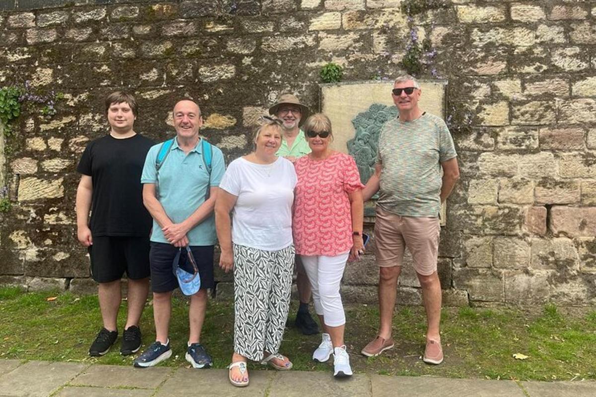a group of people standing in front of a stone wall