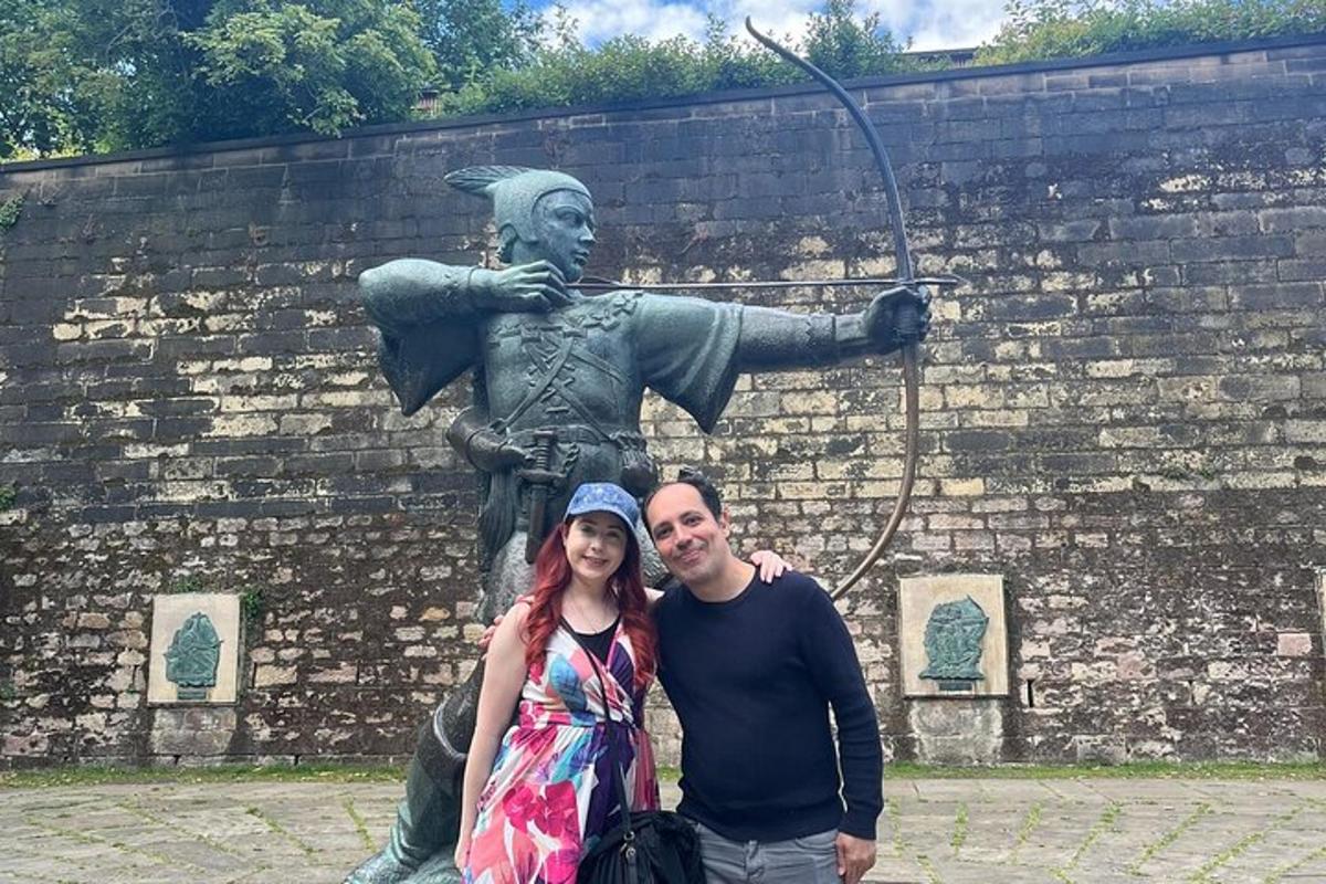 a man and a woman standing in front of a statue