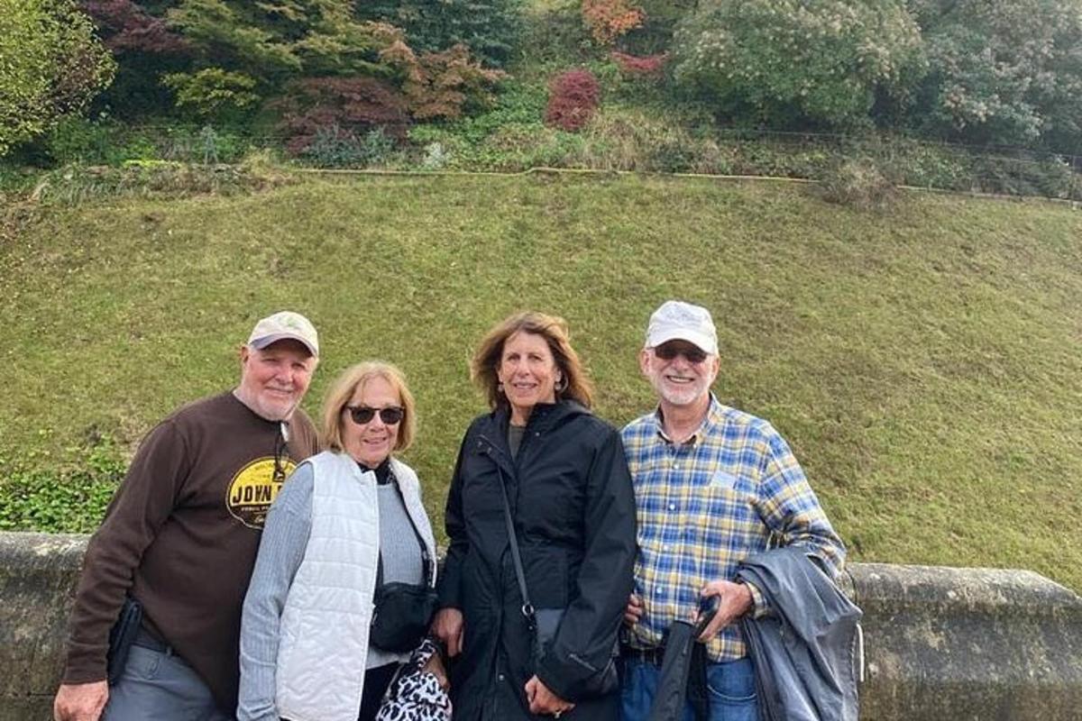 a group of people posing for a picture in front of a hill