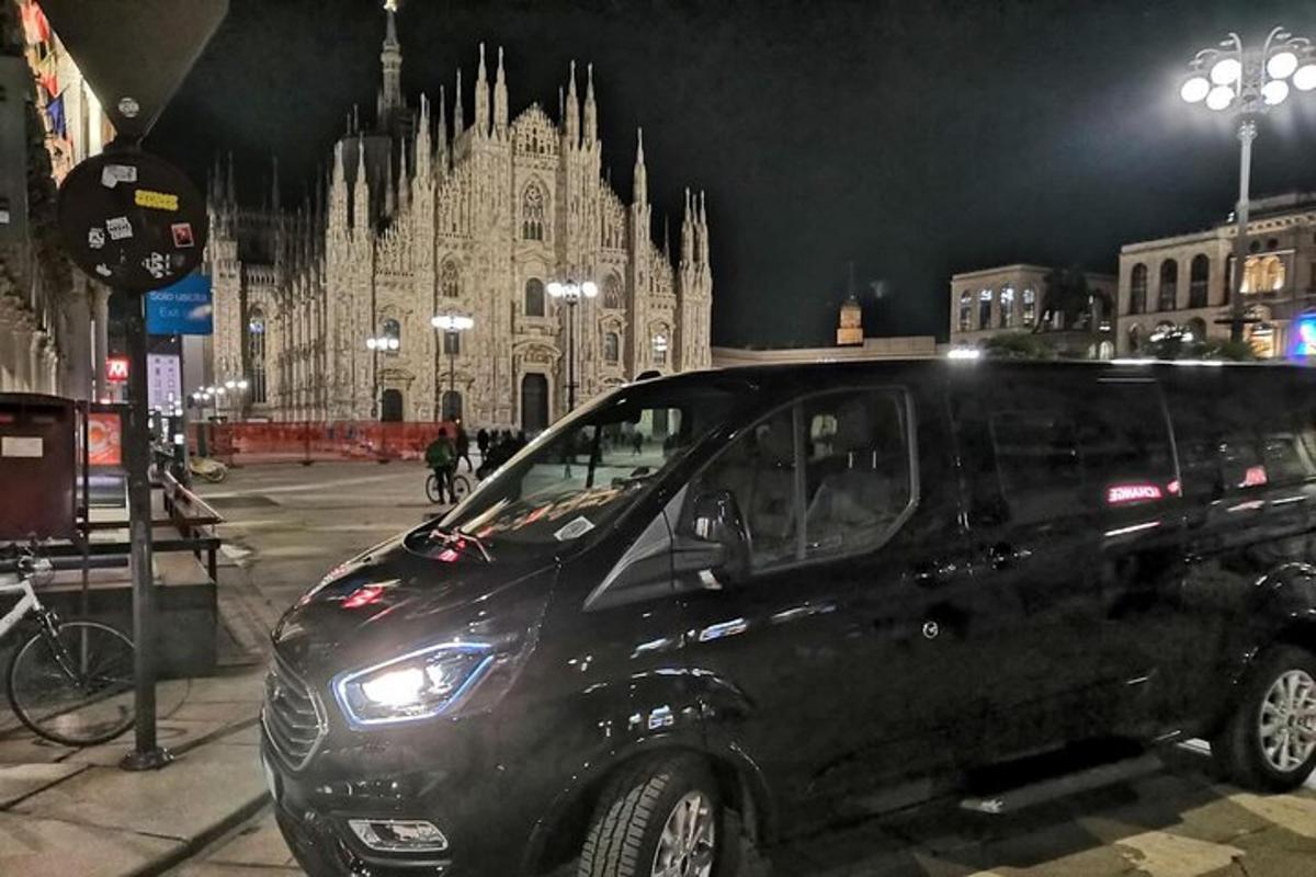 Una camioneta negra estacionada frente a un gran edificio
