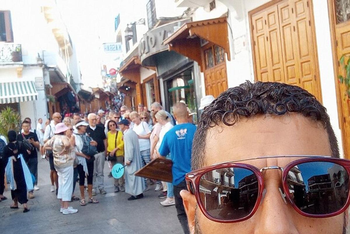Un hombre con gafas de sol frente a una multitud de personas.