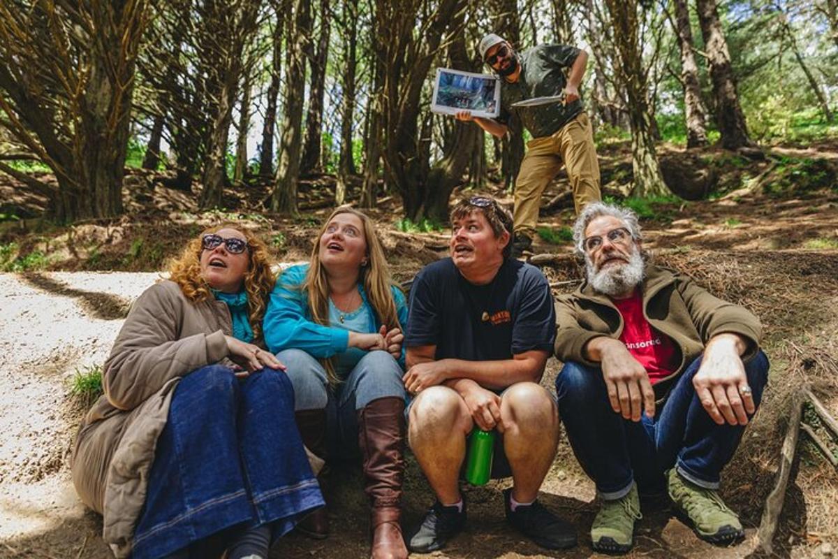 a group of people sitting on a rock in the woods