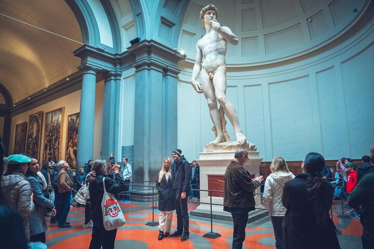 una folla di persone che guarda una statua in un museo