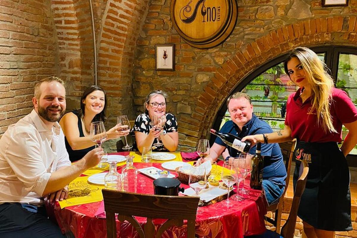 un gruppo di persone sedute attorno a un tavolo con bicchieri di vino