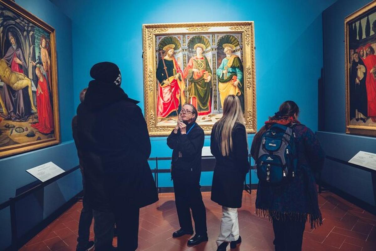 un gruppo di persone che guardano un dipinto in un museo