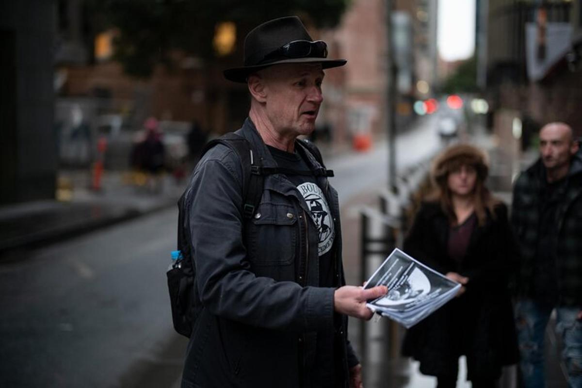 un uomo che indossa un cappello tiene in mano una rivista