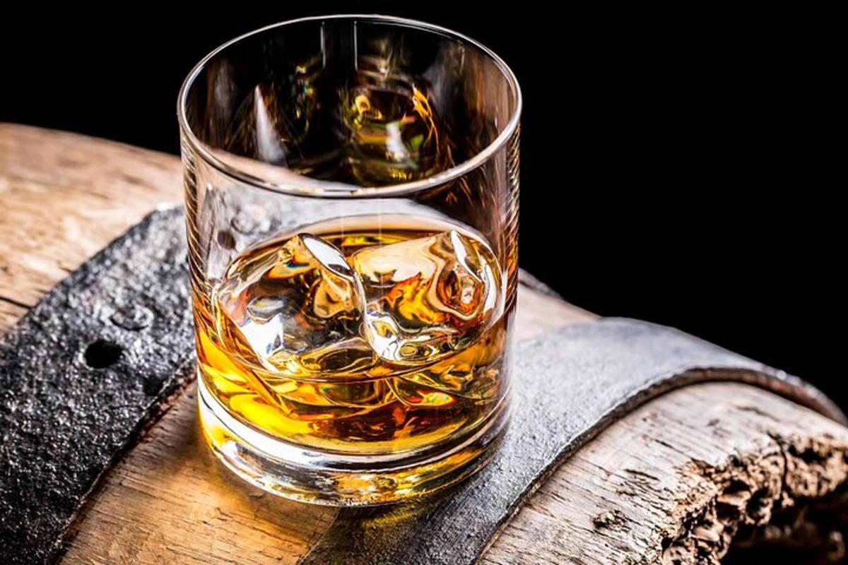 Sklenice whisky sedící na dřevěném stole