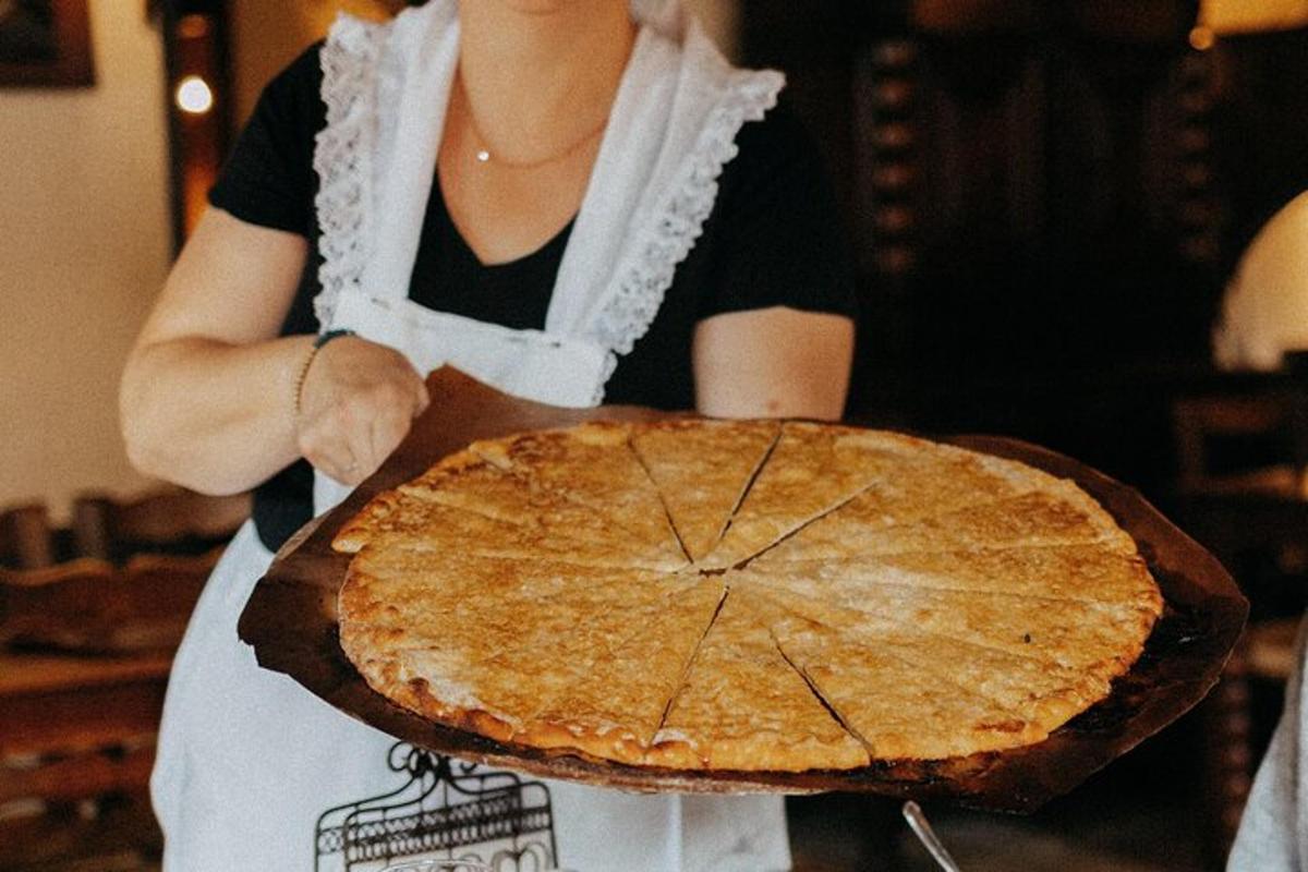 a woman holding a pie on top of a table