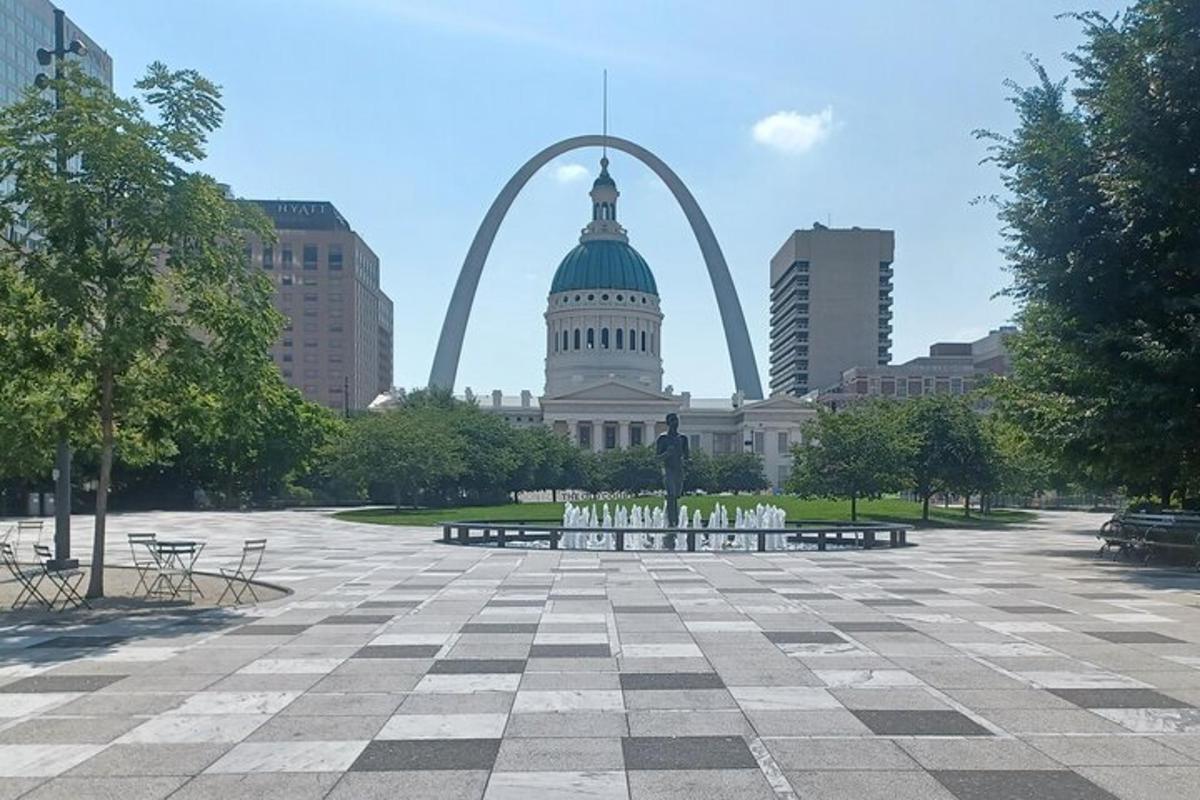 a park with benches in front of the gateway arch
