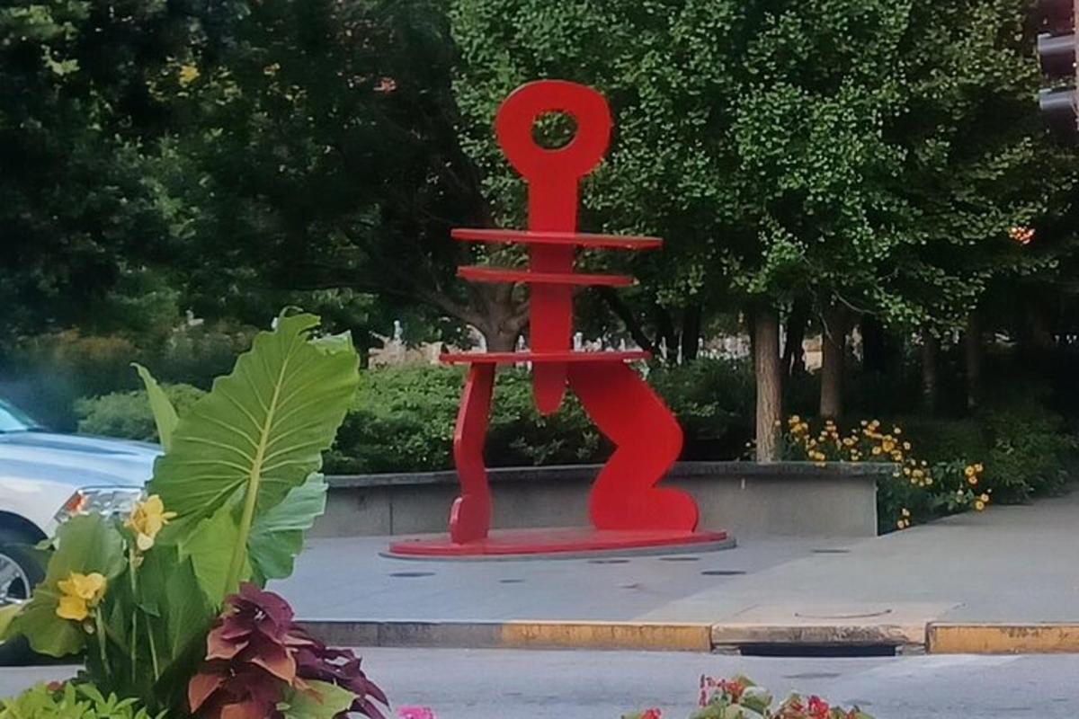 a red sculpture on the side of a street