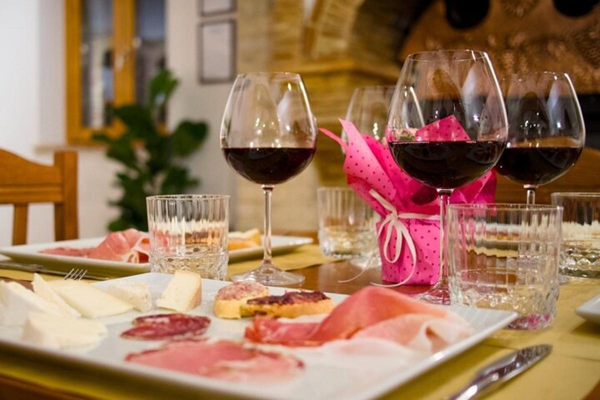 a table with two glasses of red wine and food