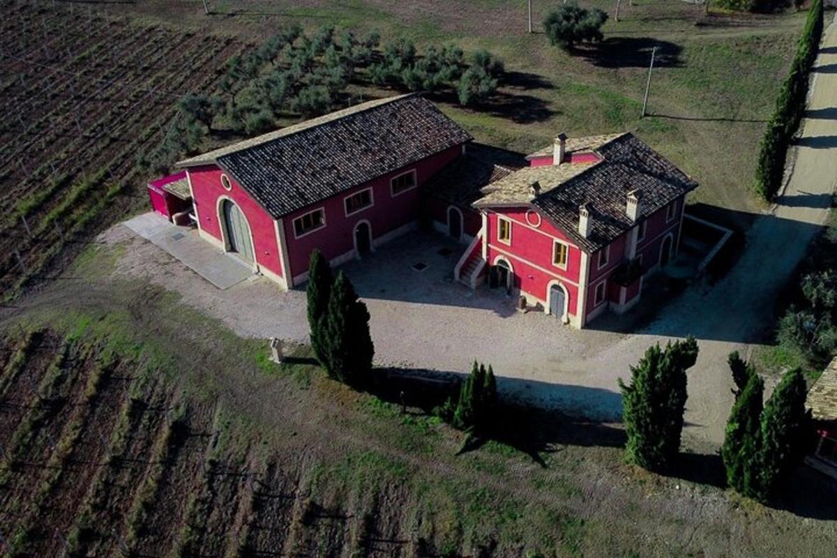 an overhead view of two red buildings in a field
