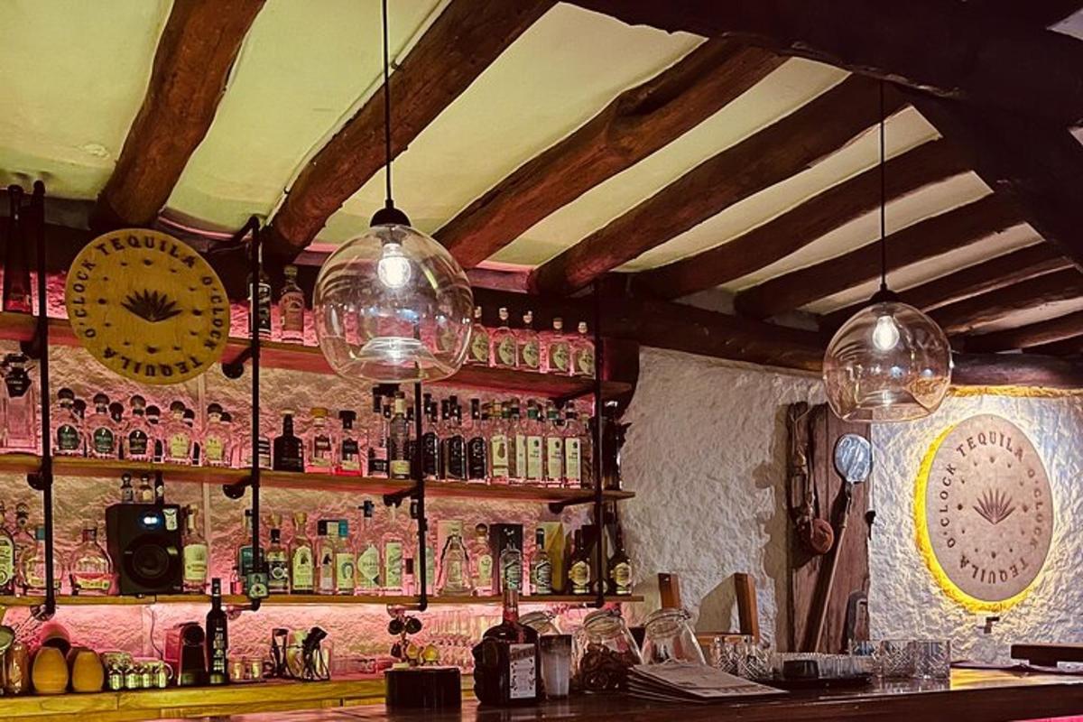 a bar with bottles and glasses on the wall