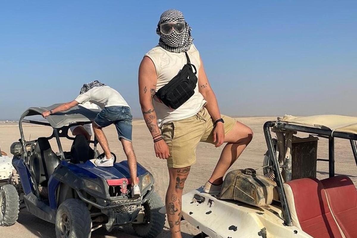 čovjek stoji u pustinji pored vozila