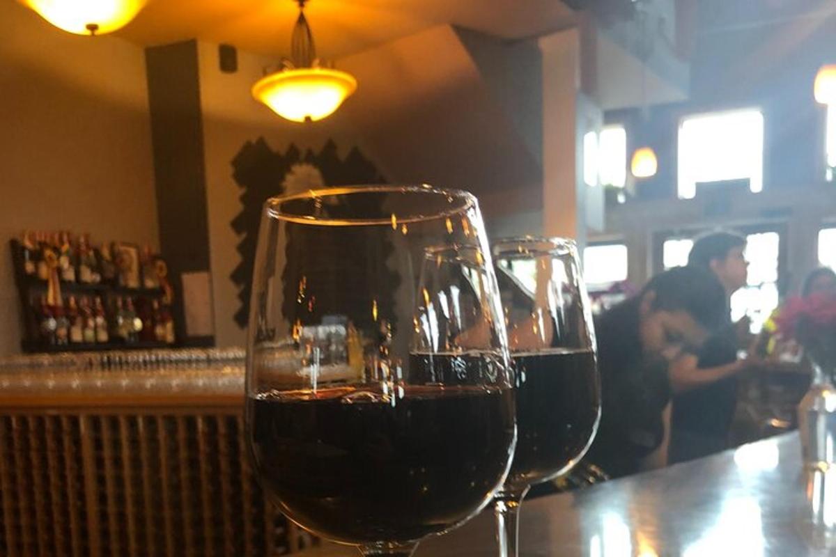 two glasses of red wine sitting on a bar