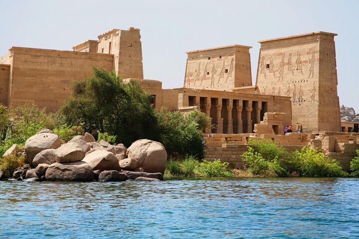 un edificio accanto a un fiume con rocce di fronte