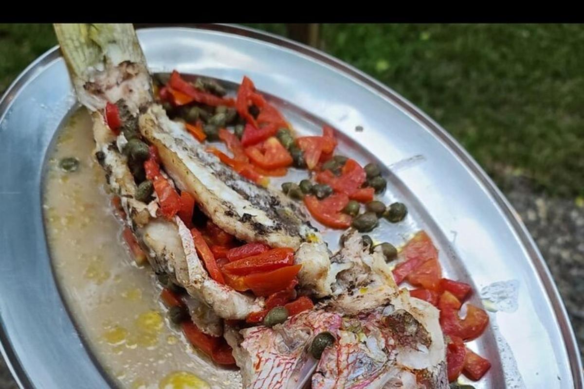 egy tányér étel egy darab hallal és zöldséggel
