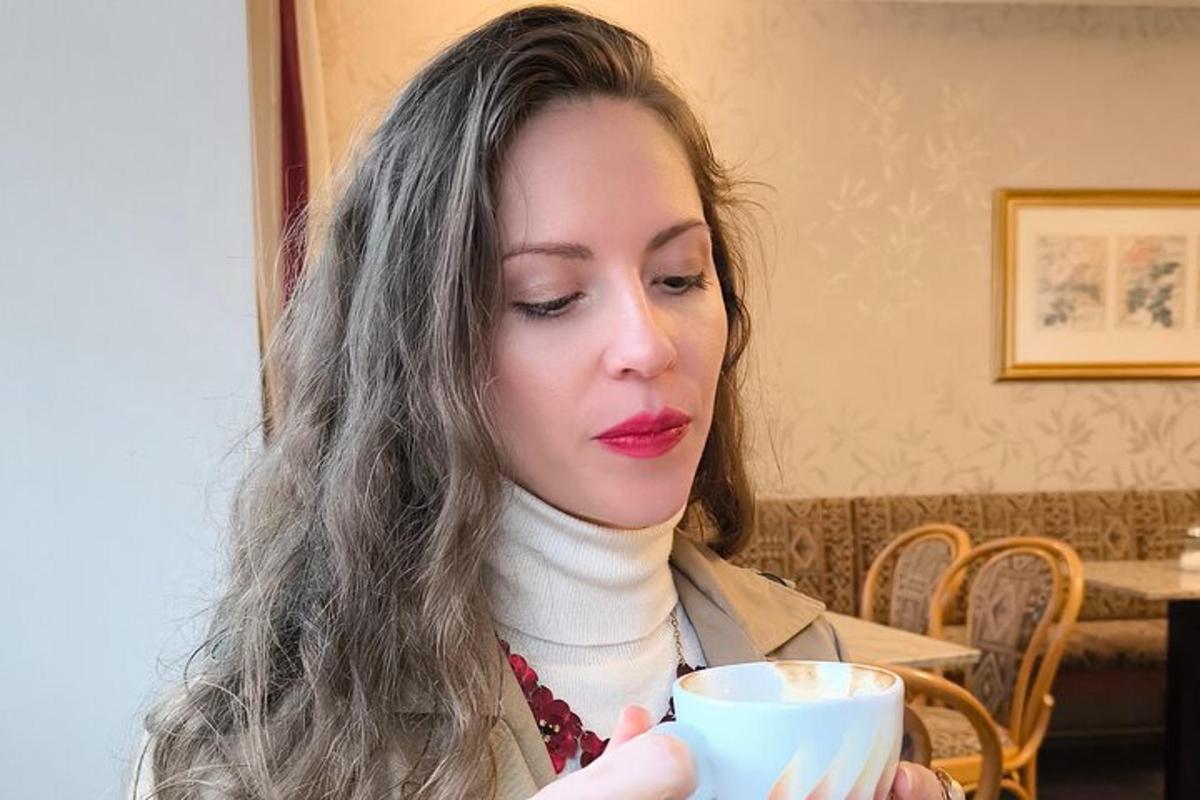 žena drží šálek kávy