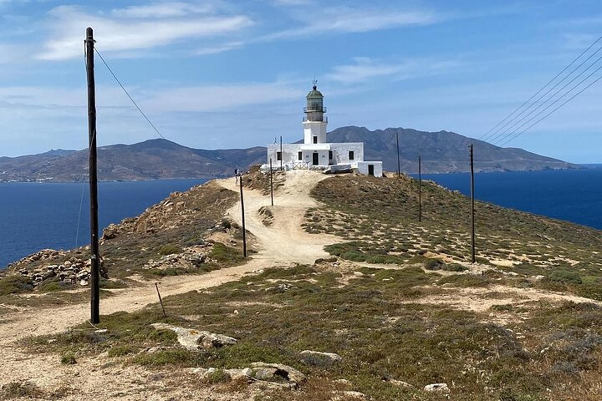 Un faro en la cima de una colina con el océano
