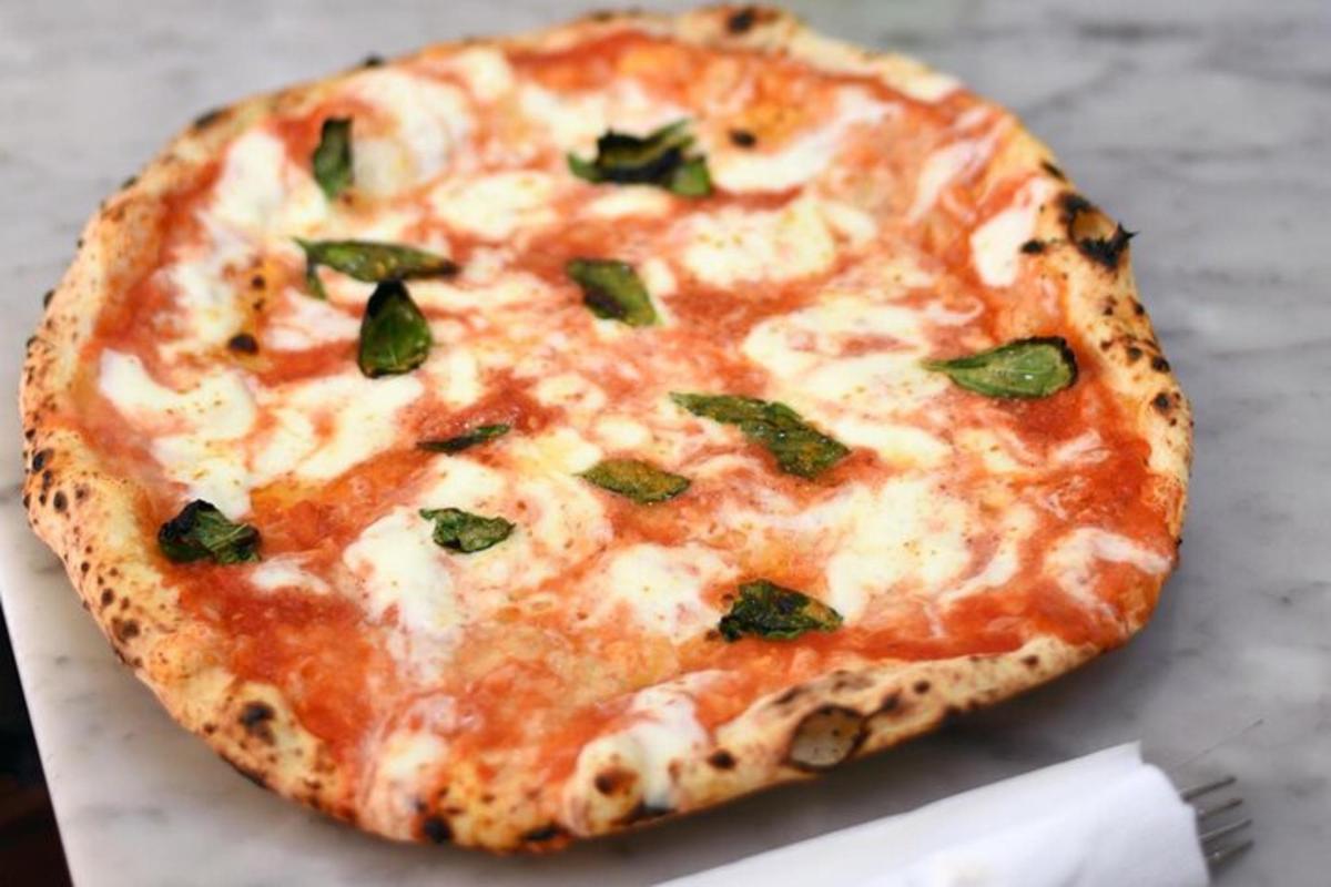 Una pizza de queso encima de una mesa