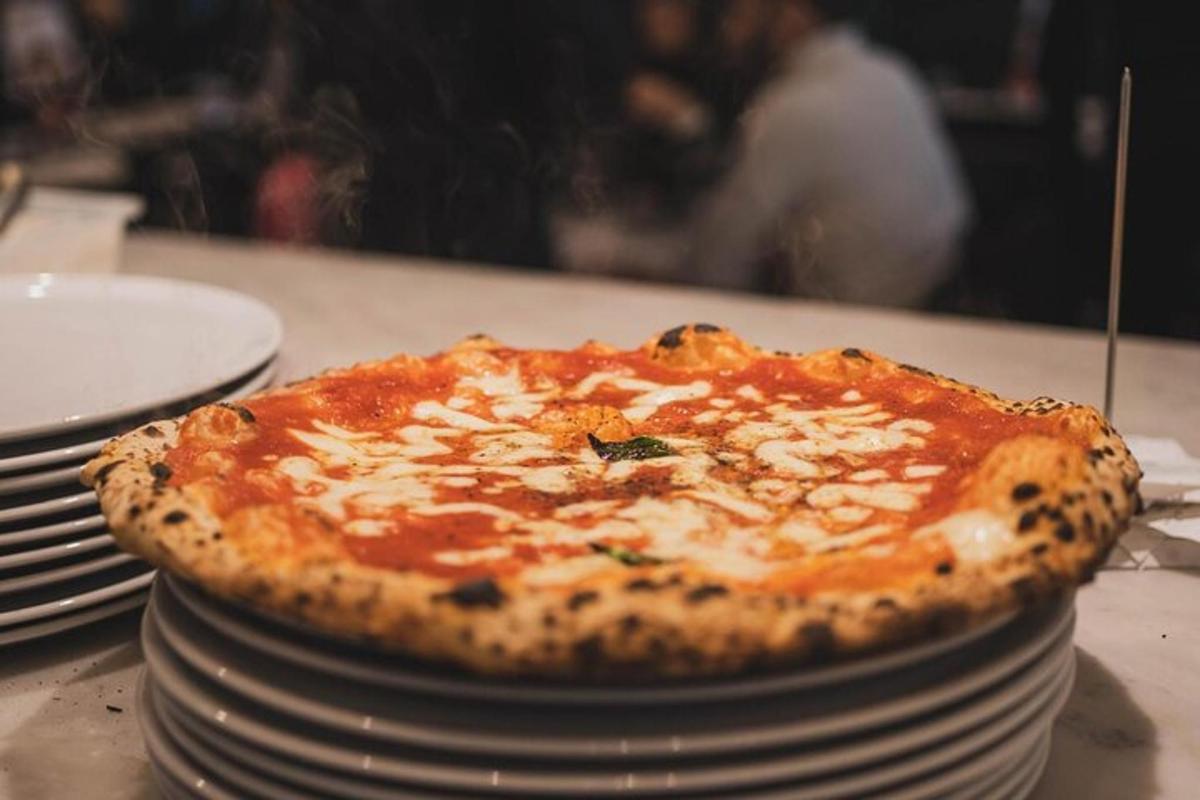 Una pizza encima de una pila de platos.