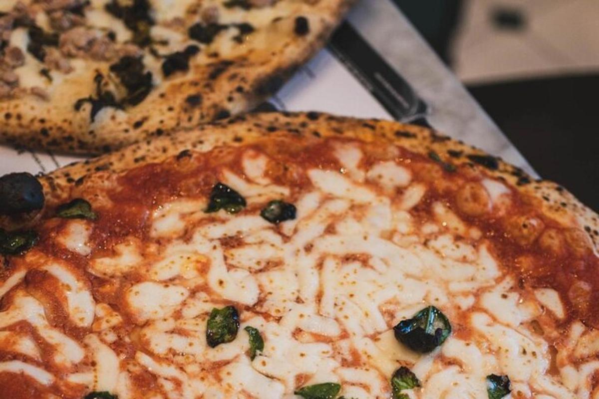 zwei Pizzen nebeneinander auf einem Tisch
