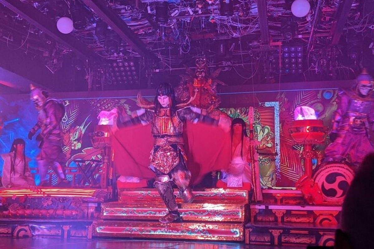 a stage with a man sitting on a red couch