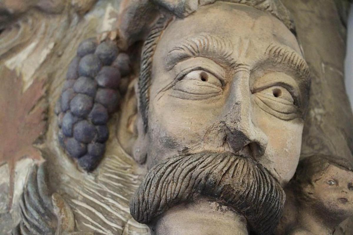 una statua di un uomo con l'uva e la barba