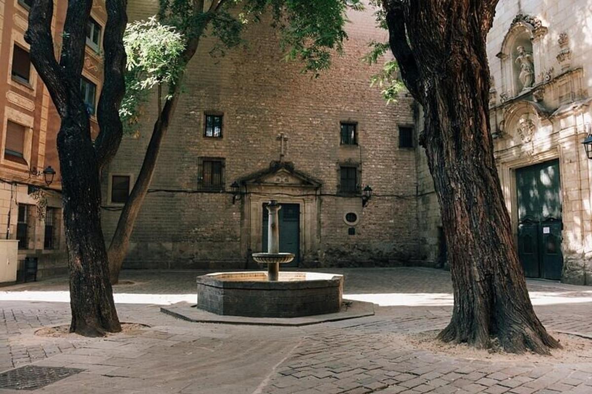 un edificio con una fontana di fronte e due alberi