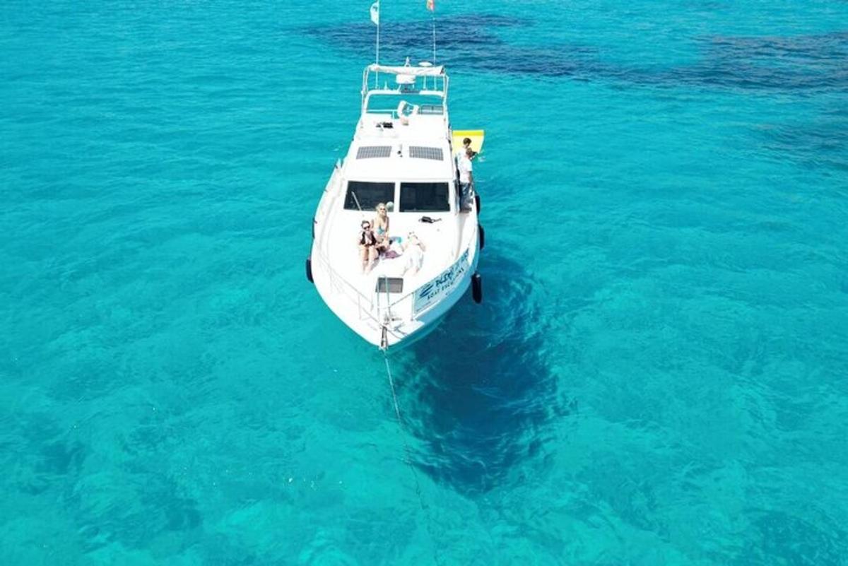 一艘白色的小船漂浮在蓝色的海水中