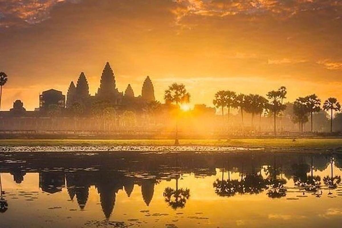 a view of a temple at sunset with the reflection in the water