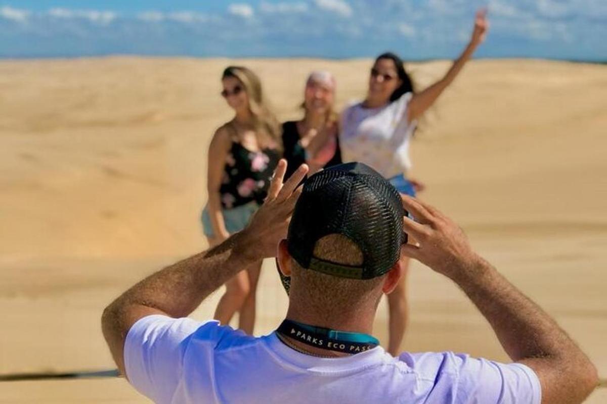 moški fotografira tri ženske na plaži