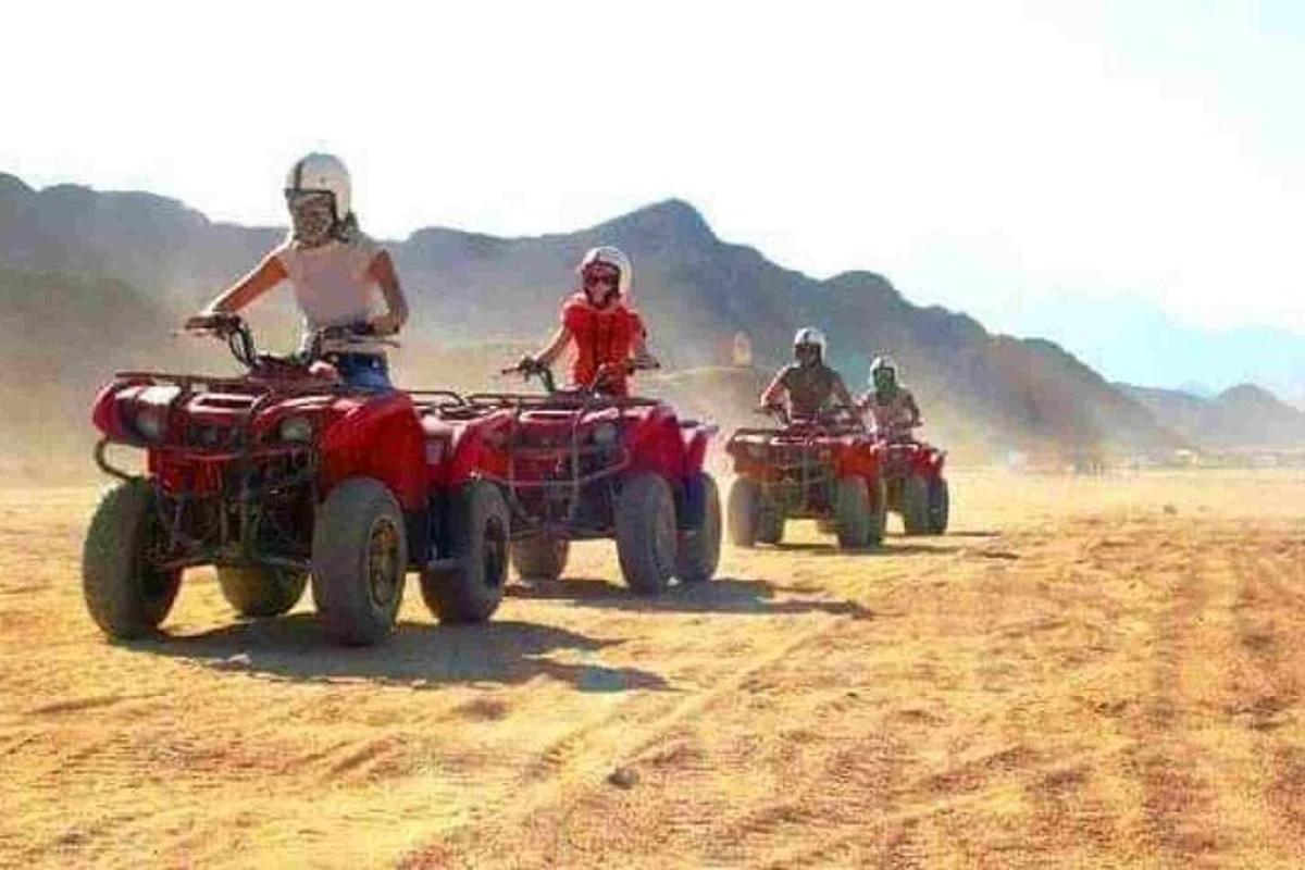 eine Gruppe von Leuten, die in der Wüste Geländefahrzeuge fahren