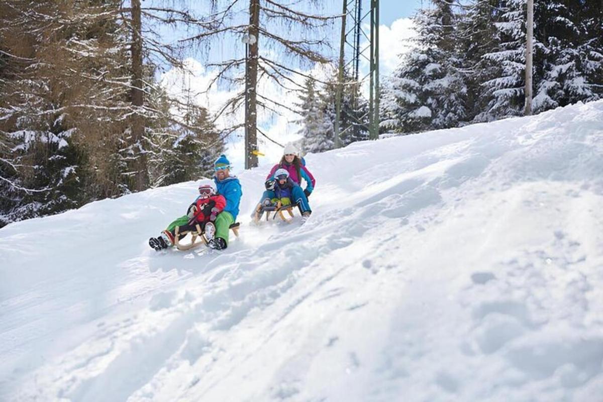 a group of three people riding down a snow covered slope