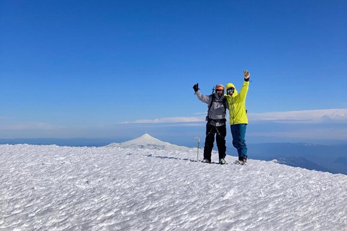 due persone in piedi sulla cima di una montagna coperta di neve