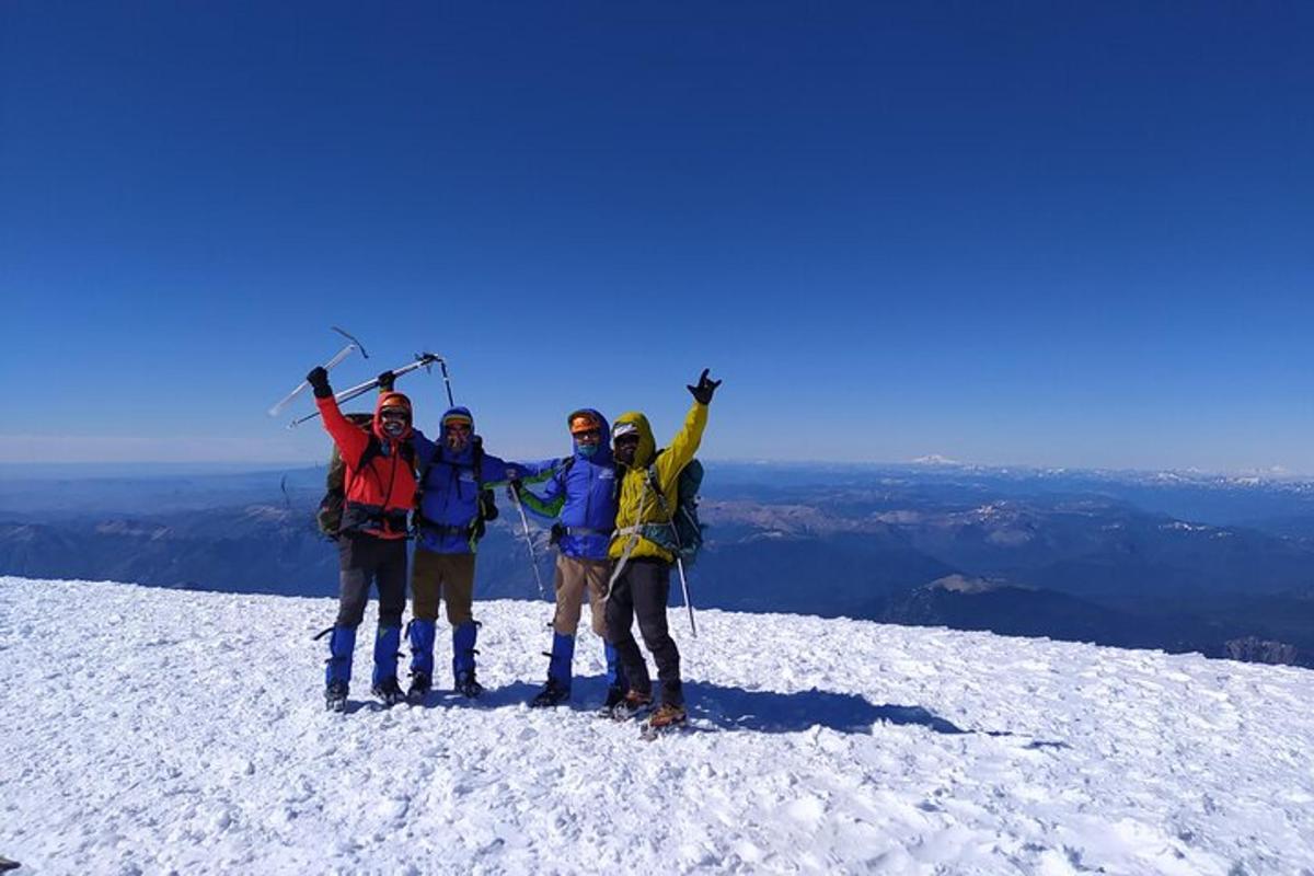 sekumpulan orang berdiri di atas gunung yang dilitupi salji