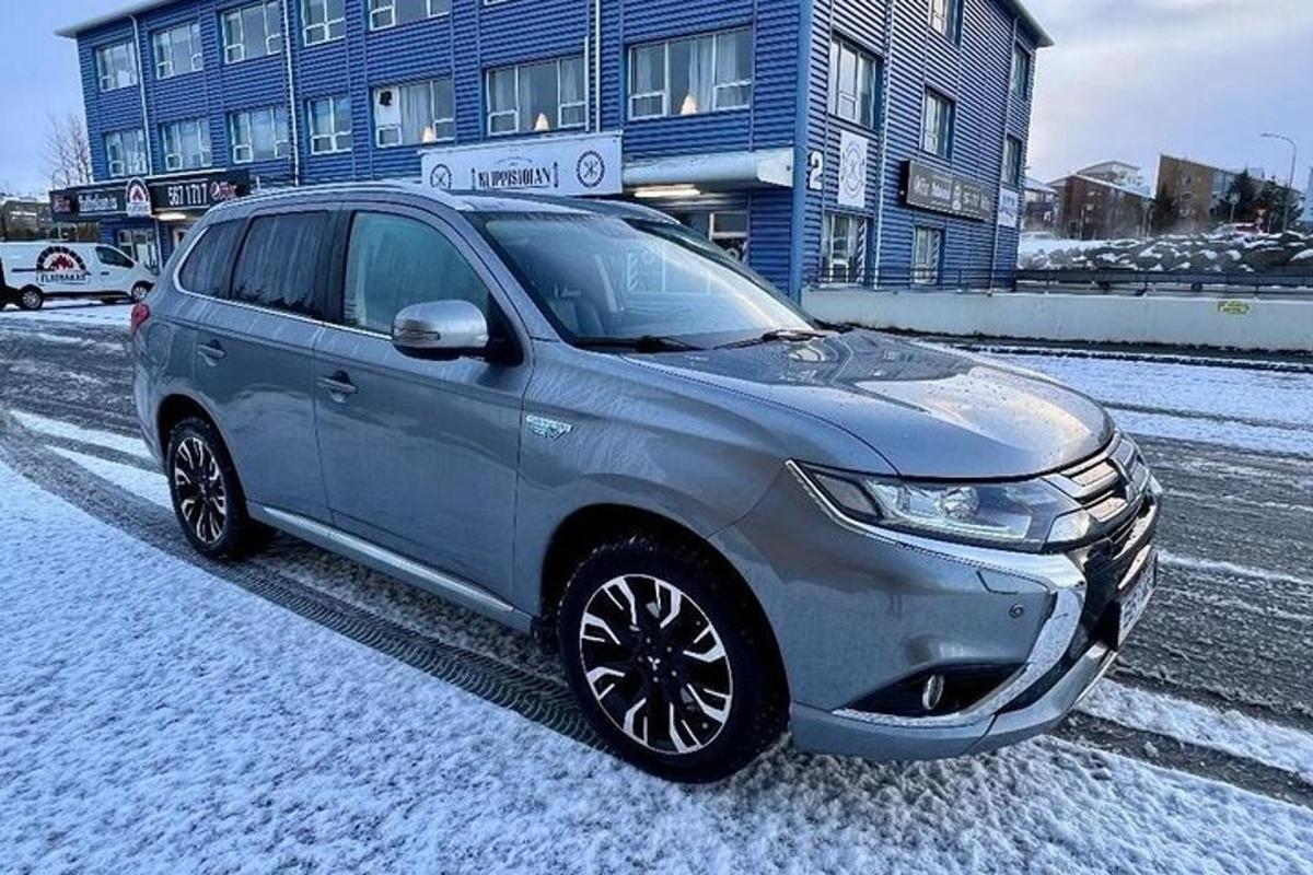 un'auto argentata parcheggiata su una strada nella neve