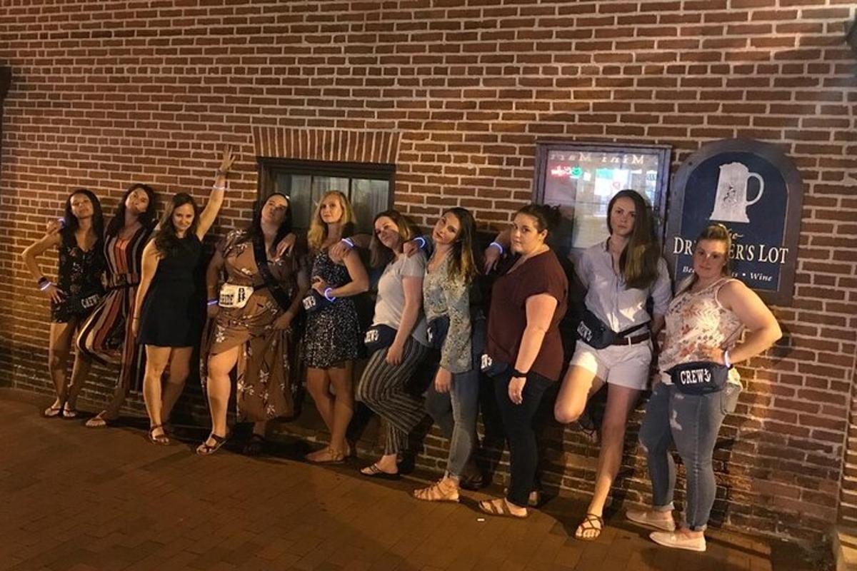 a group of women standing next to a brick wall