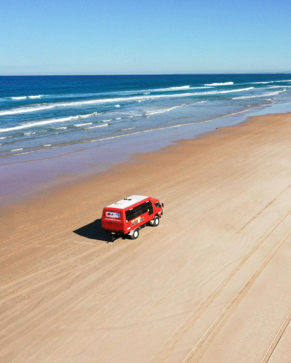 un camion rosso è parcheggiato sulla spiaggia