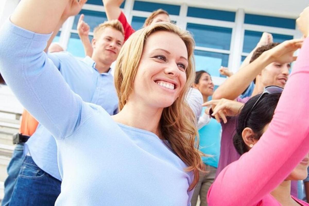 μια γυναίκα μέσα σε ένα πλήθος ανθρώπων που ζητωκραυγάζουν