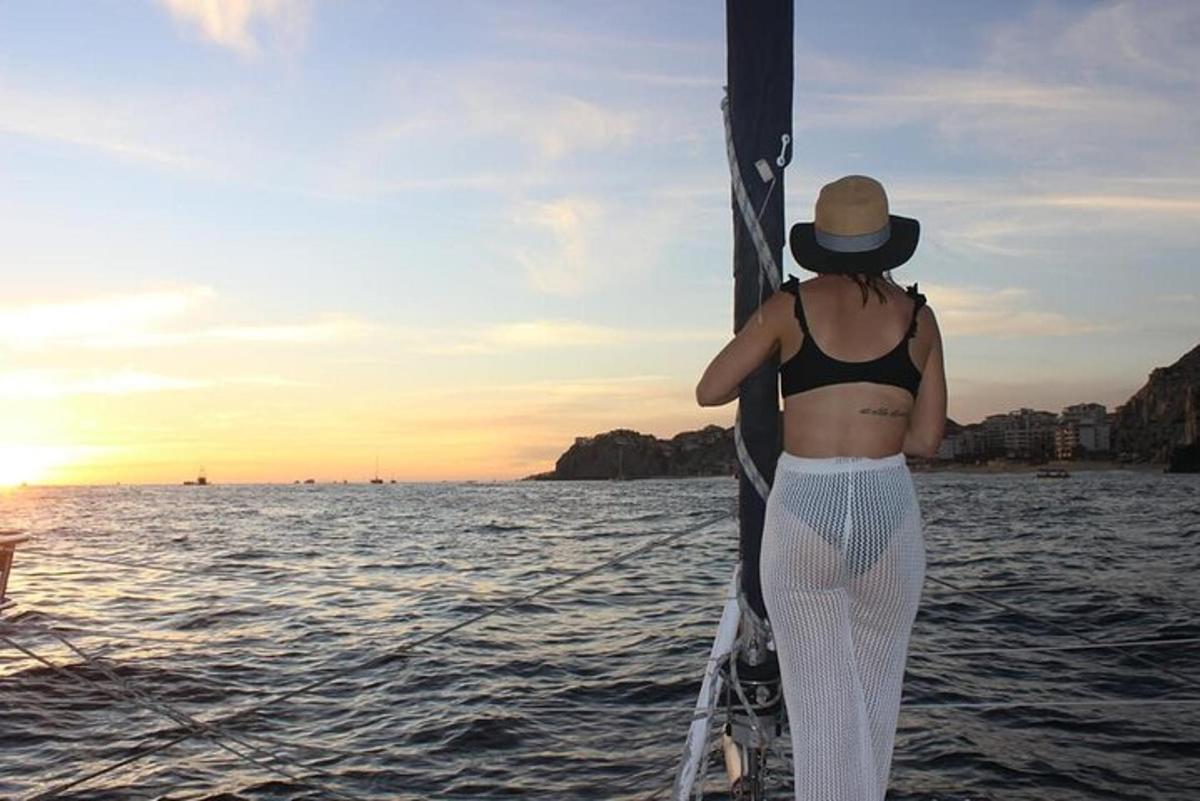 Una mujer con sombrero está parada en un velero.