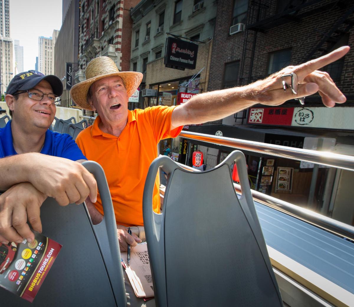 a man in a hat is pointing at a person