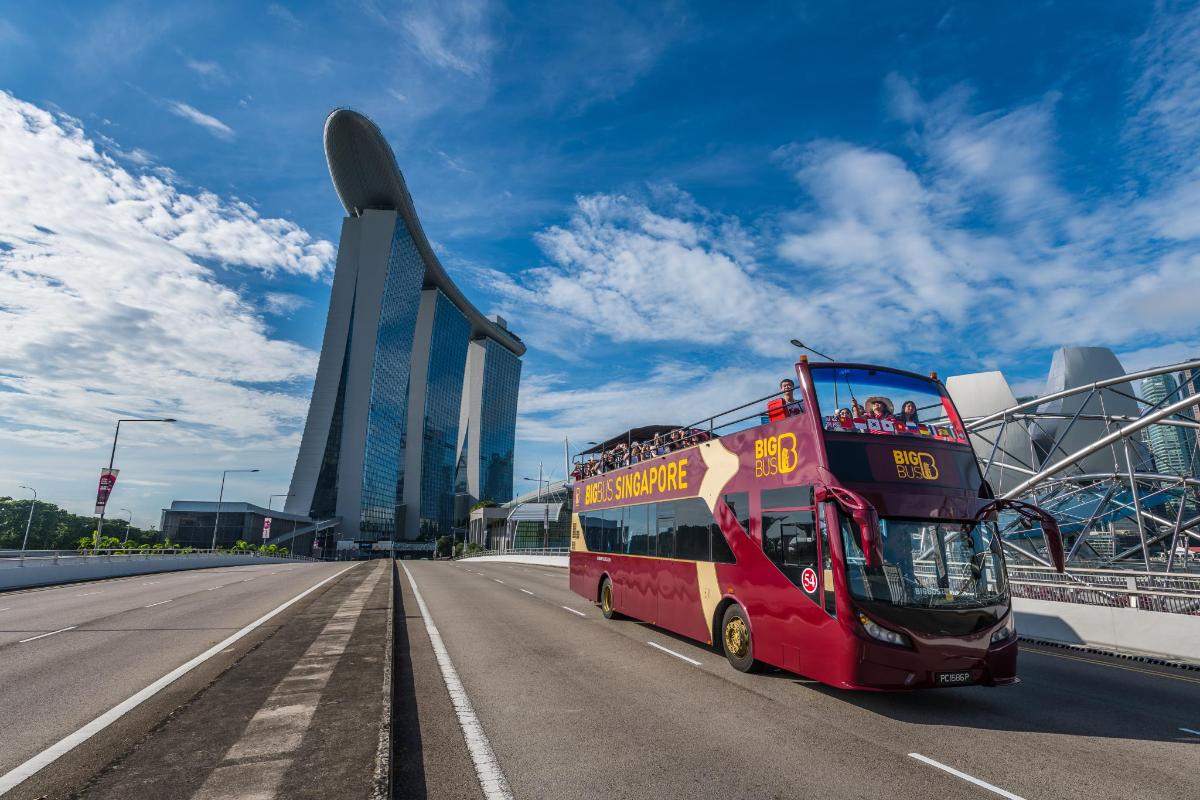 a red double decker bus driving down a highway
