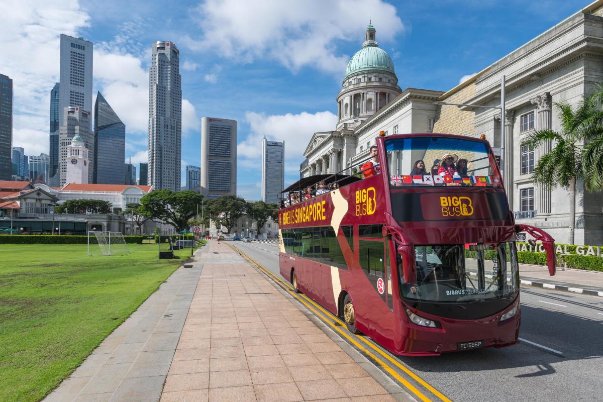 a red double decker bus parked in front of a building