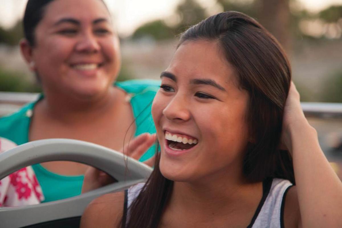 a woman is laughing while driving a car