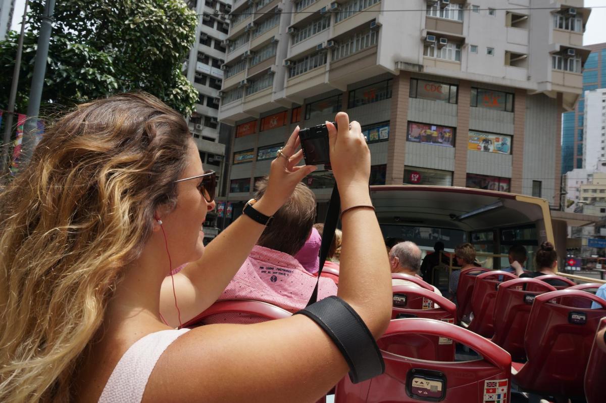 a woman taking a picture of a bus