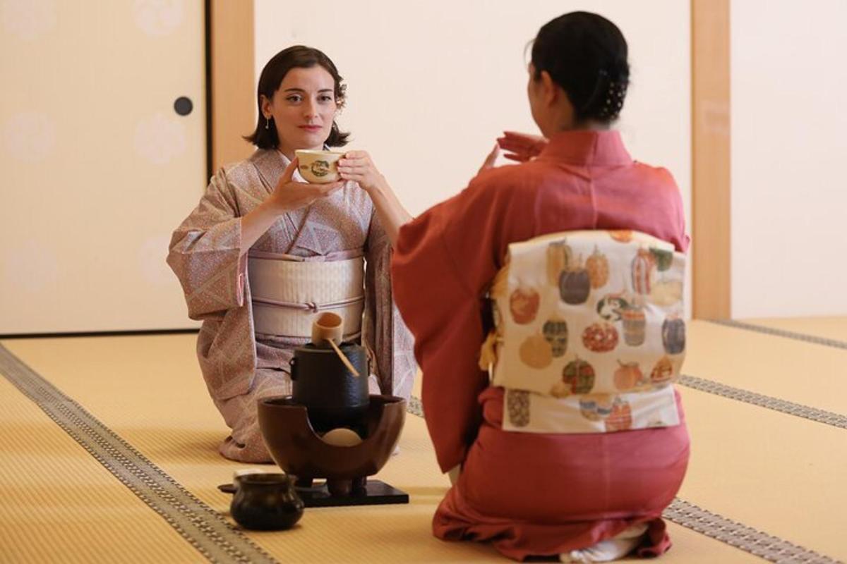 seorang wanita berkimono mengambil gambar wanita lain