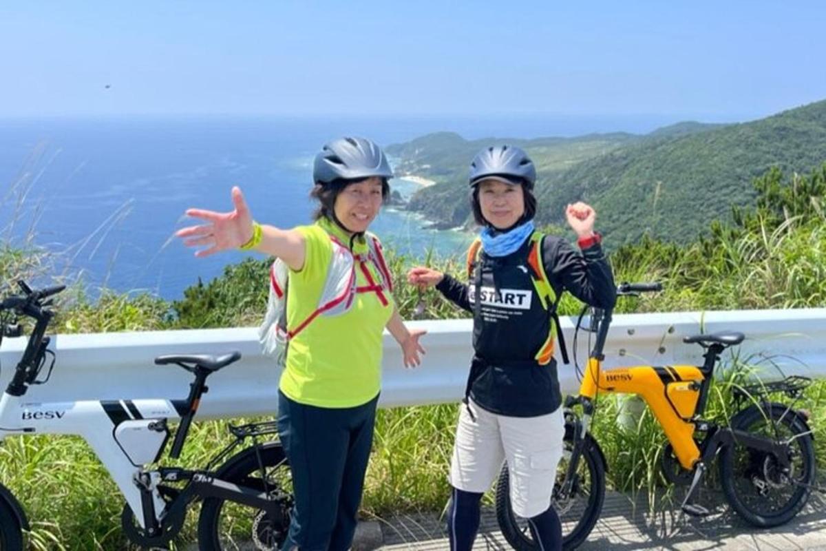 two women wearing helmets standing next to their bikes
